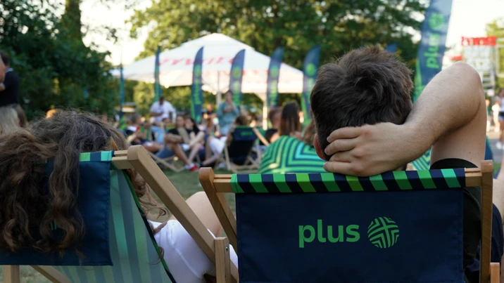 Pracownicy firmy Plus relaksują się na leżakach podczas firmowego pikniku na świeżym powietrzu