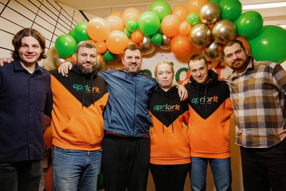 Zespół pracowników pozujący razem pod dekoracją z balonów na firmowej imprezie integracyjnej