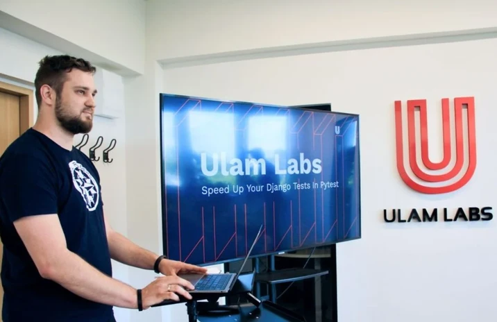 Pracownik prezentuje projekt technologiczny na spotkaniu w biurze firmy Ulam Labs