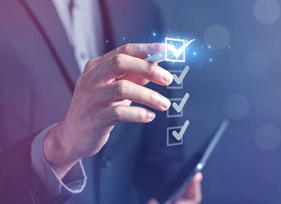 Biznesmen wskazujący na zaznaczony checklistę podczas pracy z tabletem w nowoczesnym biurze