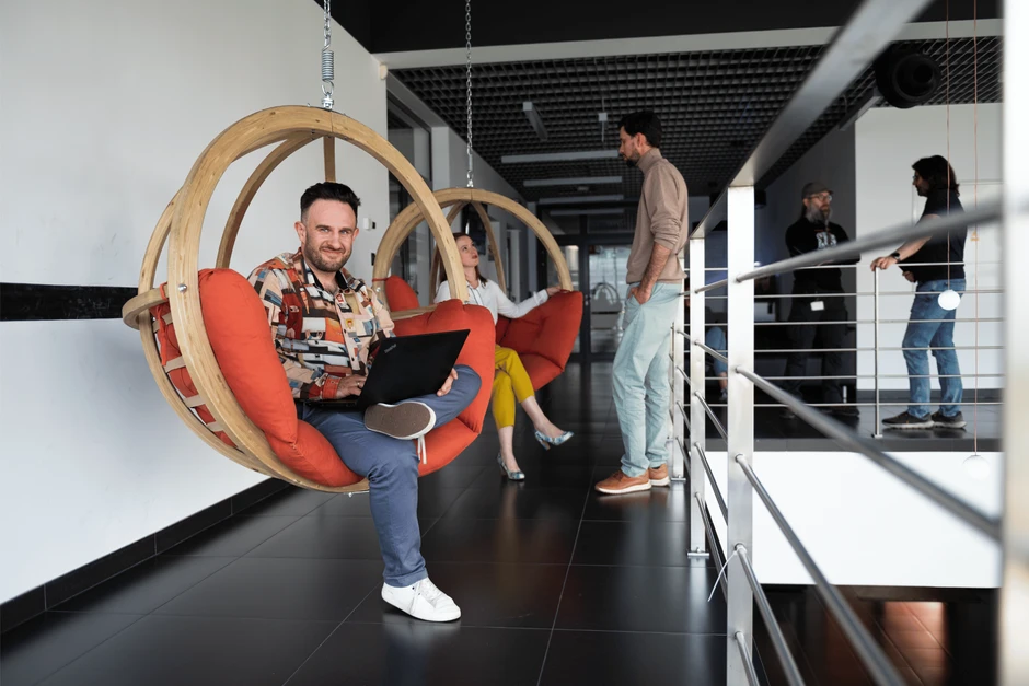 Nowoczesne biuro z relaksującymi huśtawkami i pracownikami współpracującymi w komfortowej atmosferze