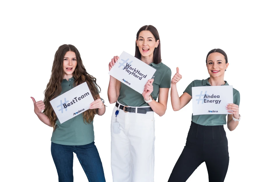 Trzy uśmiechnięte kobiety w zielonych koszulkach prezentują tabliczki z hasłami motywacyjnymi firmy Andea