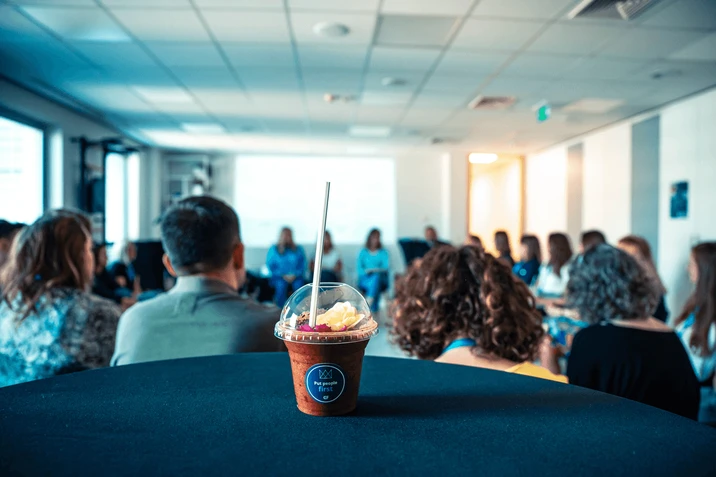 Spotkanie zespołu w nowoczesnym biurze z napojem na stole podkreślającym wartość ludzi w firmie