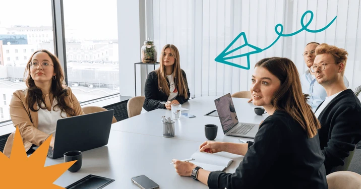 Zespół pracowników uczestniczy w spotkaniu w nowoczesnej sali konferencyjnej z dużymi oknami