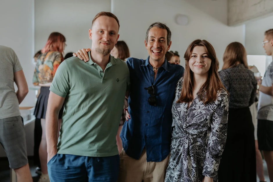 Trójka uśmiechniętych pracowników podczas nieformalnego spotkania integracyjnego w biurze