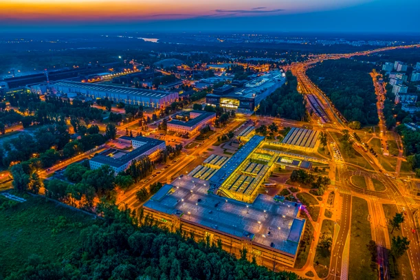 Wieczorny widok z lotu ptaka na nowoczesny kompleks biurowy otoczony zielenią w dużym mieście