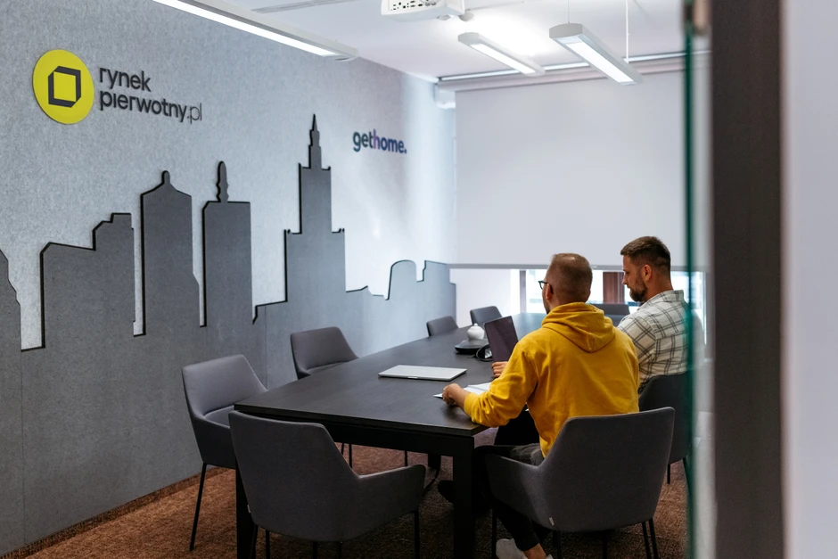 Nowoczesna sala konferencyjna z dekoracją ścienną miasta i dwoma pracownikami przy stole