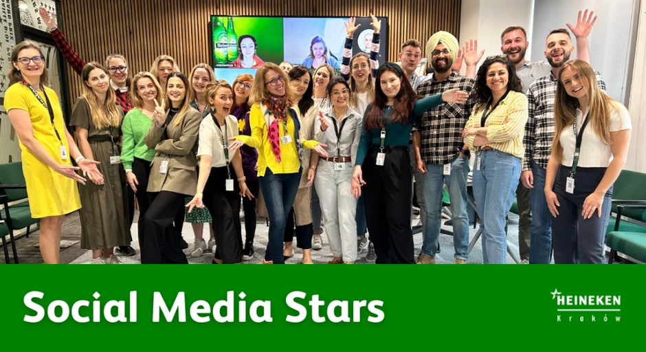 Zespół Social Media Heineken Kraków pozujący radośnie na tle sali konferencyjnej z ekranem