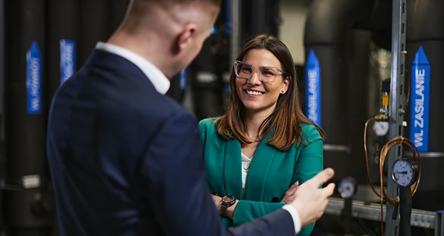 Dwójka pracowników w biurze technicznym rozmawia o projekcie w profesjonalnej atmosferze