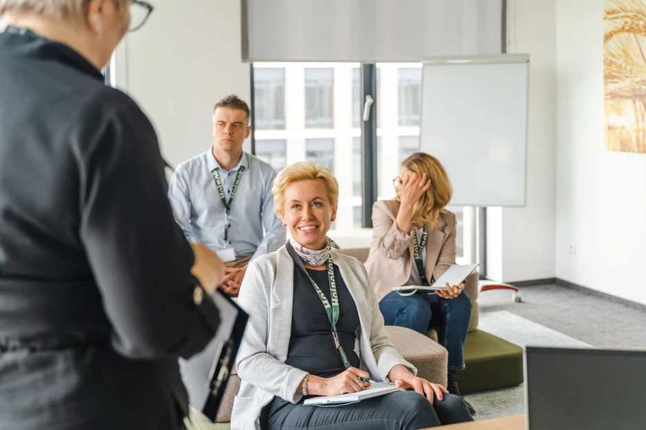 Grupa pracowników podczas szkolenia w nowoczesnym biurze z notatkami i prezentacją