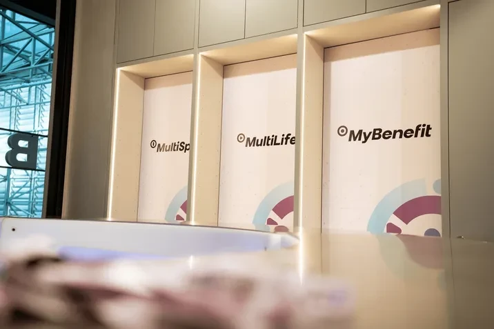 Nowoczesne wnętrze biura z trzema podświetlonymi panelami prezentującymi nazwy produktów MultiSport, MultiLife i MyBenefit