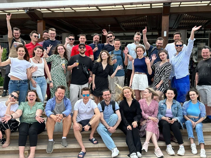 Zespół pracowników na wspólnym zdjęciu podczas firmowego spotkania na świeżym powietrzu