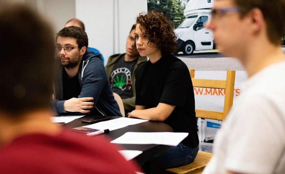 Zespół podczas spotkania w firmowym biurze, skoncentrowani na omawianiu projektu i wymianie pomysłów