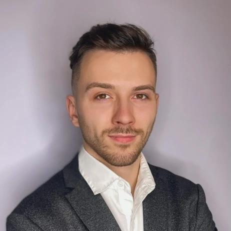 Młody profesjonalista w garniturze na neutralnym tle, zdjęcie do profilu pracodawcy