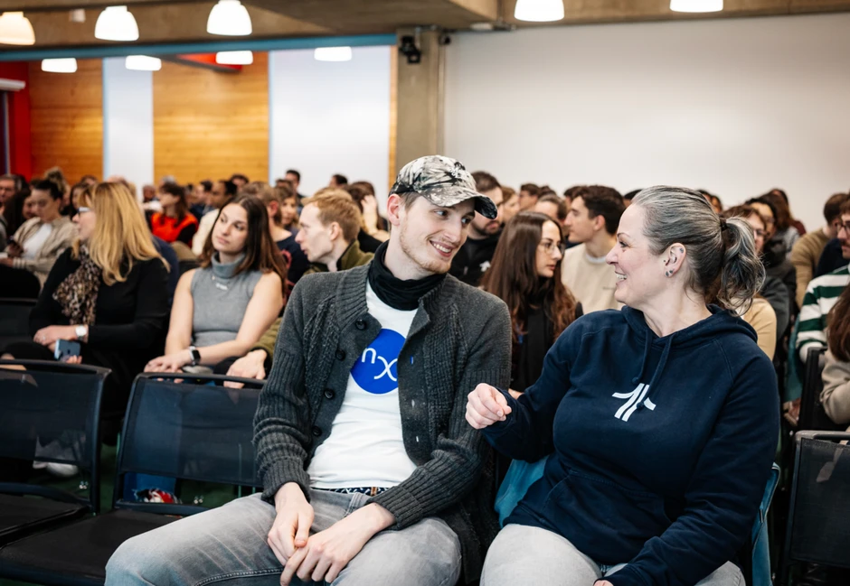 Ludzie rozmawiają i uśmiechają się na wydarzeniu firmowym w nowoczesnej sali konferencyjnej