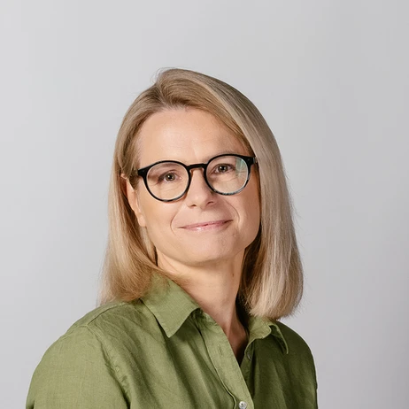 Portret uśmiechniętej kobiety w okularach i zielonej koszuli na jasnym tle w profilu firmy