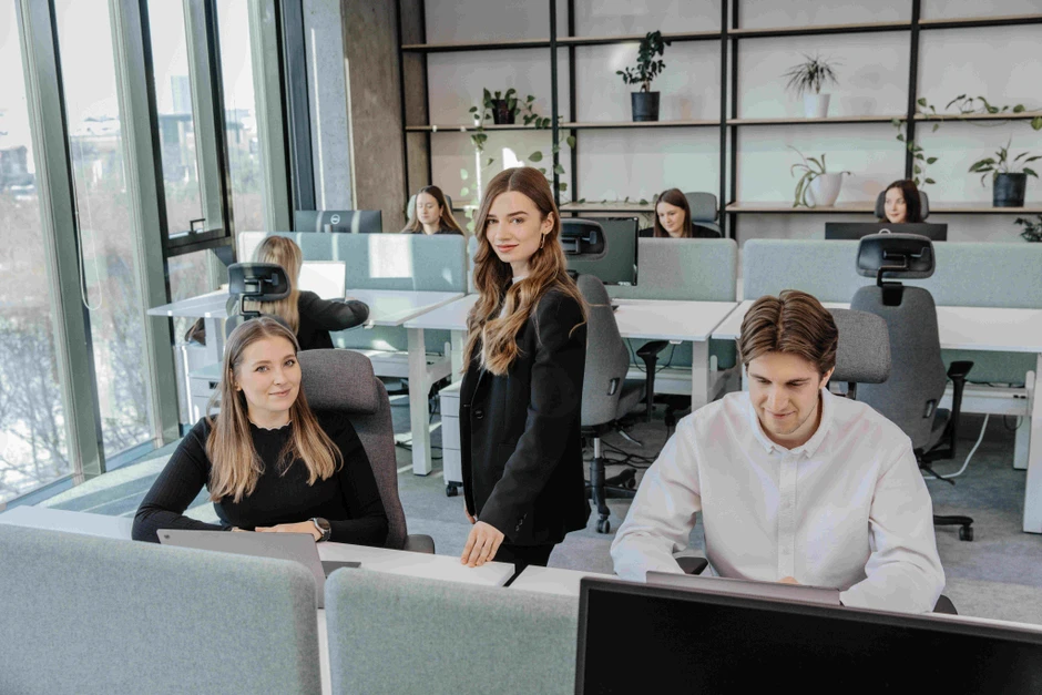 Nowoczesne biuro z zespołem młodych profesjonalistów pracujących przy komputerach w jasnym wnętrzu