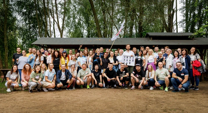 Duża grupa pracowników pozująca na zdjęcie podczas firmowego wyjazdu integracyjnego na łonie natury