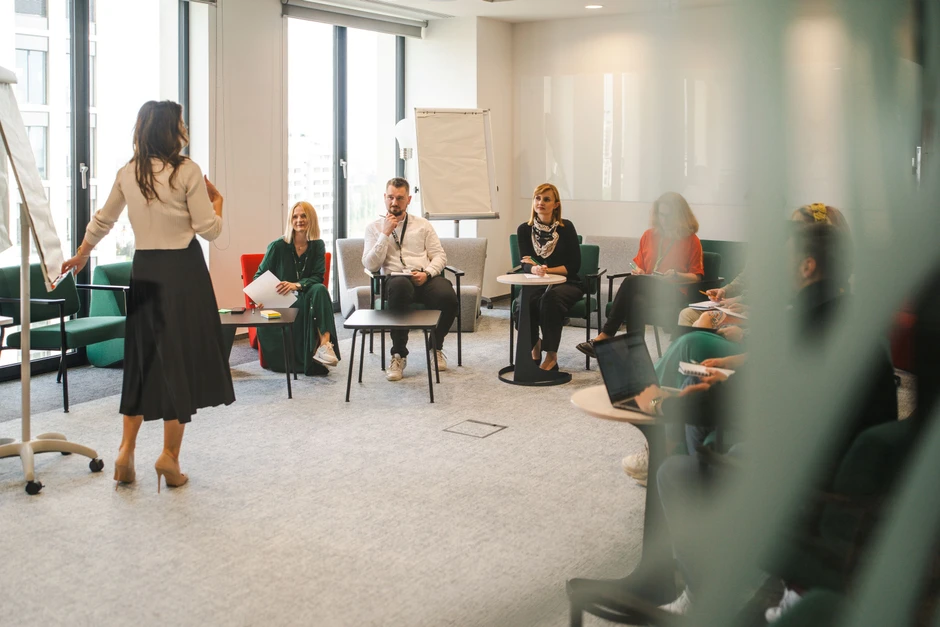 Zespół pracowników podczas szkolenia w nowoczesnej sali konferencyjnej w jasnym biurze