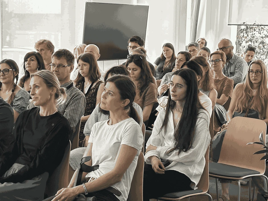 Grupa zaangażowanych osób uczestniczy w szkoleniu firmowym w jasnym, nowoczesnym pomieszczeniu