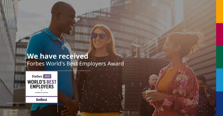 Trzy osoby rozmawiające i uśmiechające się podczas spotkania firmowego na zewnątrz biura