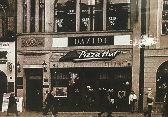 Front restauracji Pizza Hut w historycznym budynku z przechodniami na ulicy przed wejściem