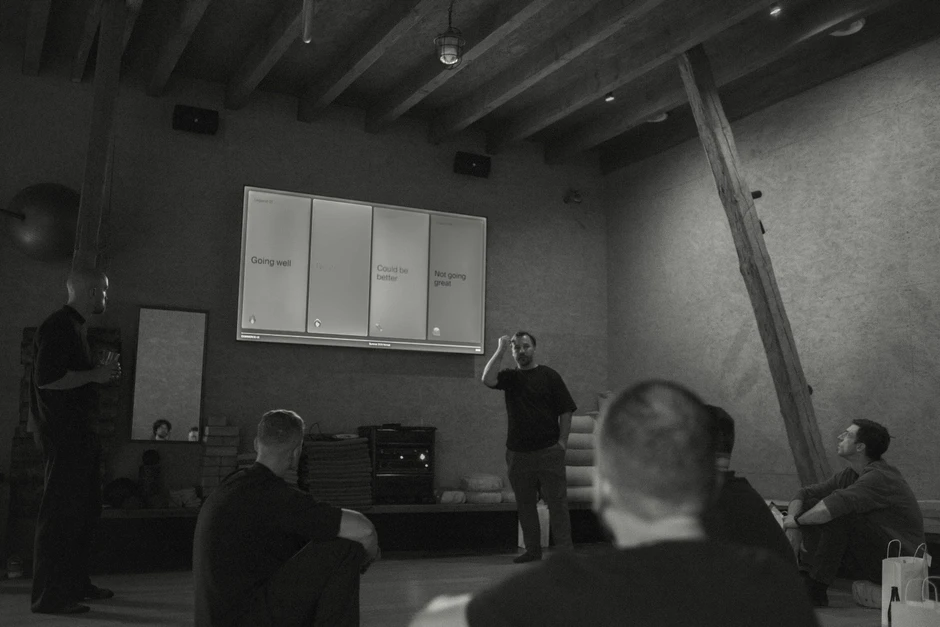 Spotkanie zespołowe w luźnej atmosferze z prezentacją na dużym ekranie w nowoczesnym biurze