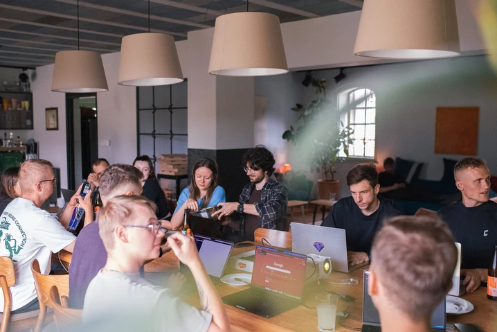 Ludzie pracujący przy laptopach w nowoczesnym biurze podczas spotkania zespołowego