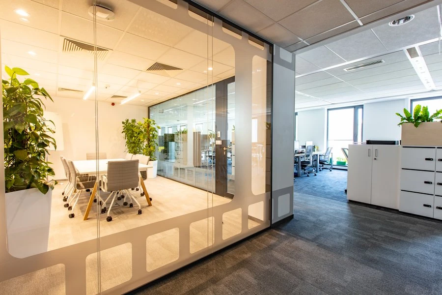 Nowoczesne biuro z witrynami ze szkła, roślinami i jasnym pomieszczeniem konferencyjnym