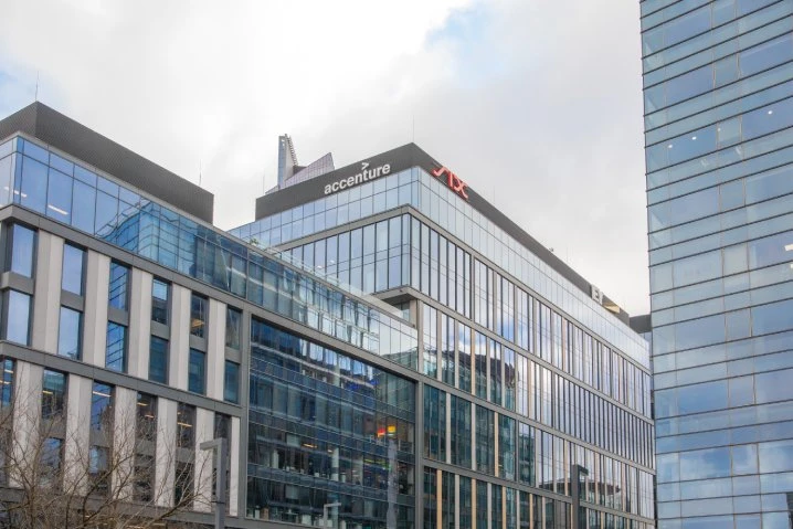 Nowoczesne biurowce z przeszklonymi elewacjami z logo firmy Accenture na dachu w strefie biznesowej miasta