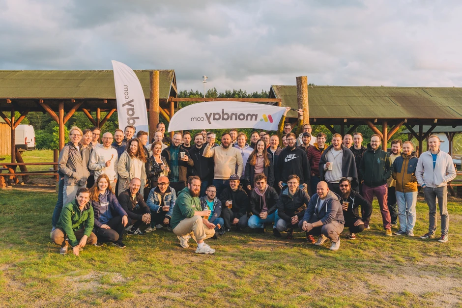 Duża grupa osób na firmowym spotkaniu integracyjnym na świeżym powietrzu w urokliwym plenerze