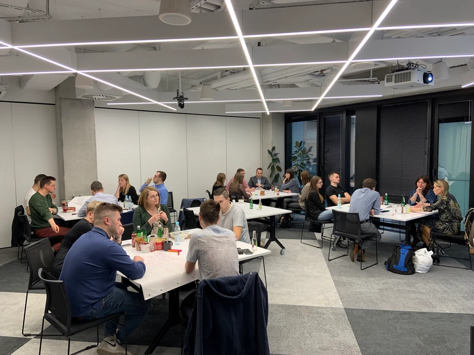 Zespół pracowników w nowoczesnej sali konferencyjnej podczas burzy mózgów i wspólnej pracy przy stołach