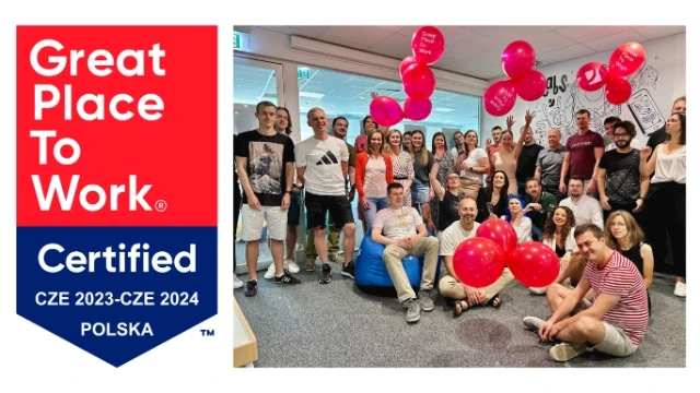Grupa uśmiechniętych pracowników świętuje certyfikat Great Place To Work w biurze z balonami