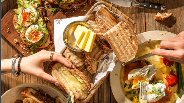 Śniadanie w firmowym stylu z tostami, świeżymi warzywami i serem serwowanym przy wspólnym stole