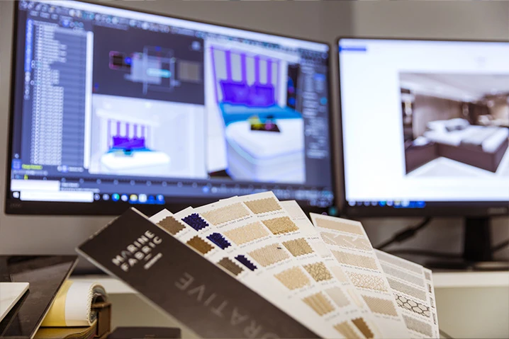 Katalog próbek materiałów na tle komputerowych wizualizacji wnętrz sypialni na dwóch monitorach