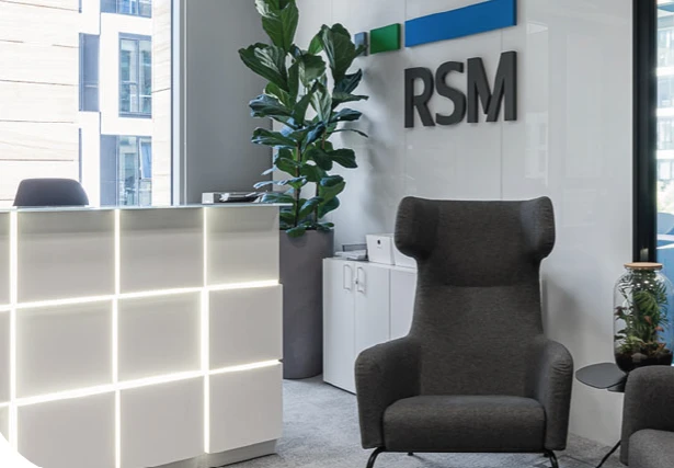 Nowoczesne biuro firmy RSM z eleganckim fotelem, recepcją i roślinami w jasnym wnętrzu
