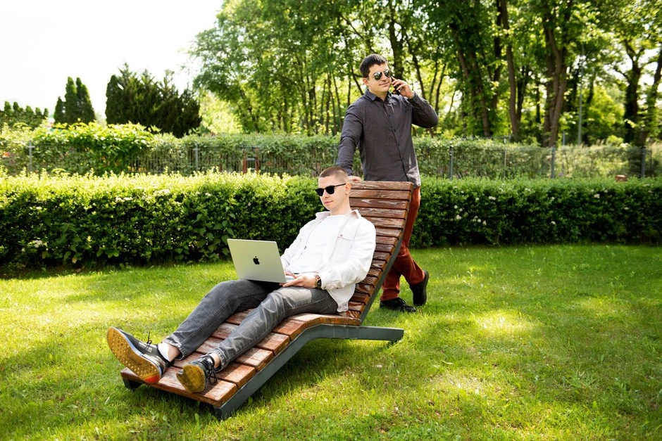 Dwóch młodych mężczyzn pracujących na świeżym powietrzu w zielonym parku podczas słonecznego dnia