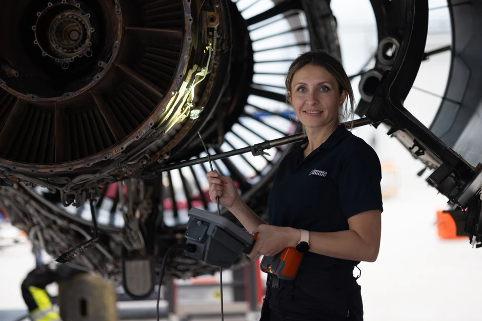 Kobieta inżynier przeprowadza diagnostykę silnika samolotu w hali obsługi technicznej lotniska