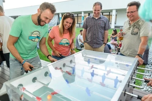 Pracownicy firmy grający w piłkarzyki podczas integracyjnego spotkania na świeżym powietrzu