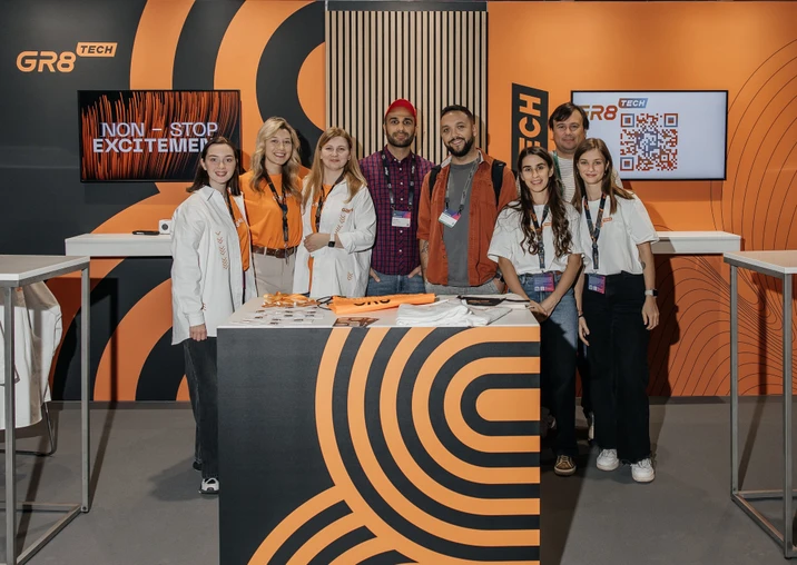 Zespół GR8 Tech prezentuje się na stoisku targowym z nowoczesnym brandingiem i materiałami promocyjnymi