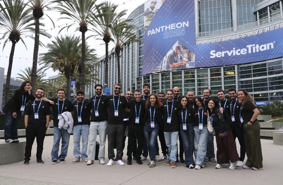 Grupa ludzi w identycznych koszulkach z identyfikatorami na tle budynku ServiceTitan podczas wydarzenia Pantheon 2025