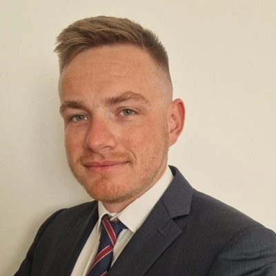 Portret młodego mężczyzny w eleganckim garniturze i krawacie na jasnym tle do profilu firmowego