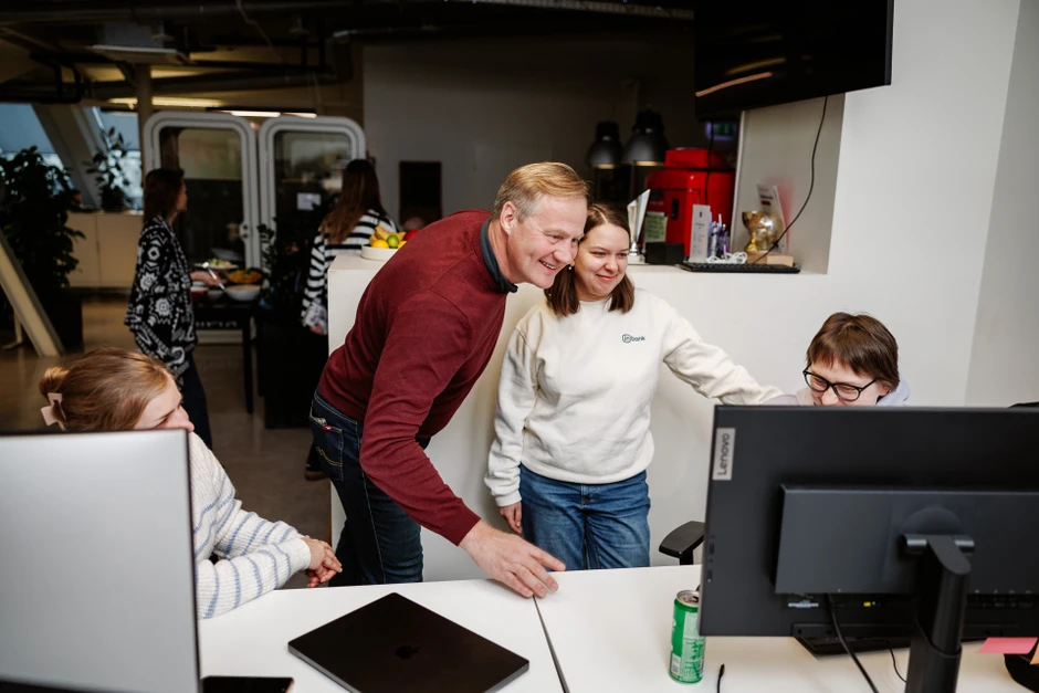 Pracownicy biura wspólnie patrzą na ekran komputera podczas pracy i omawiania projektu