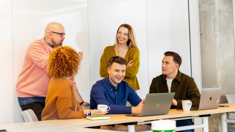 Zespół współpracujących pracowników w biurze podczas burzy mózgów i pracy na laptopach przy stole
