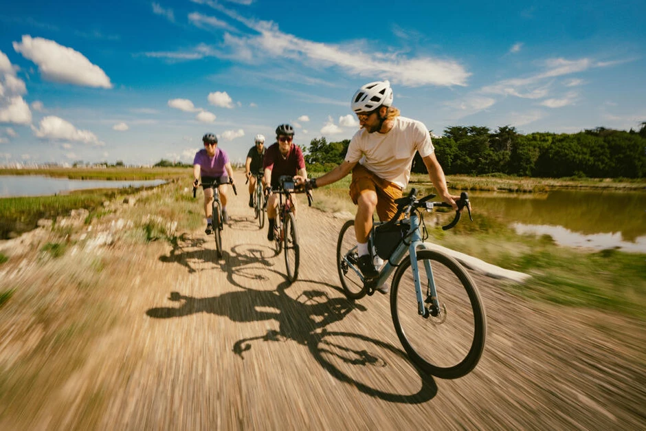 Zespół pracowników na rowerach cieszy się wspólną wycieczką poza miastem piękną słoneczną pogodą