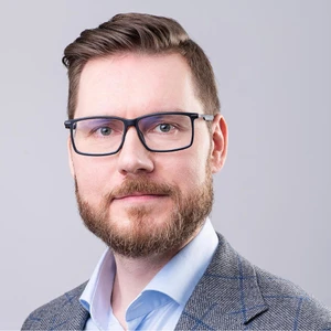 Profesjonalne zdjęcie mężczyzny z okularami w eleganckim garniturze na jasnym tle do profilu pracodawcy