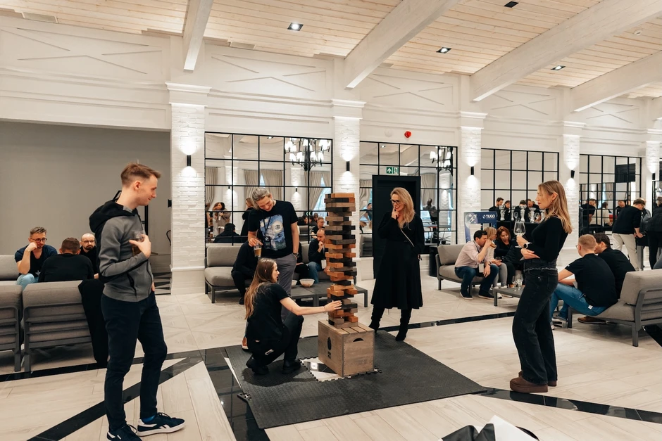 Pracownicy firmy spędzają czas razem grając w dużą drewnianą grę w nowoczesnym biurze