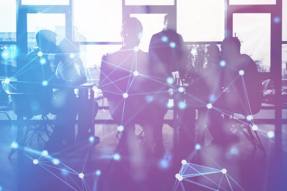 Zespół pracowników podczas spotkania w nowoczesnym biurze z nałożonymi elementami grafiki sieciowej