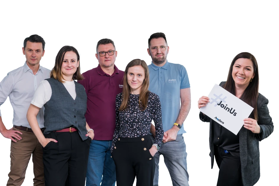 Zespół pracowników firmy Andea pozujący uśmiechnięci na jasnym tle z hasłem rekrutacyjnym JoinUs
